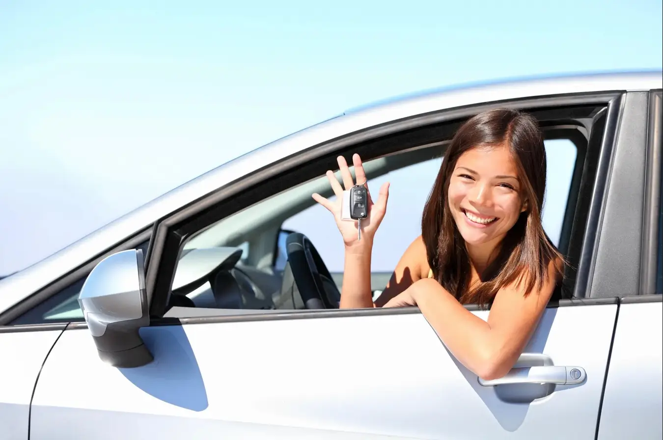 A smiling driver holding her car keys
